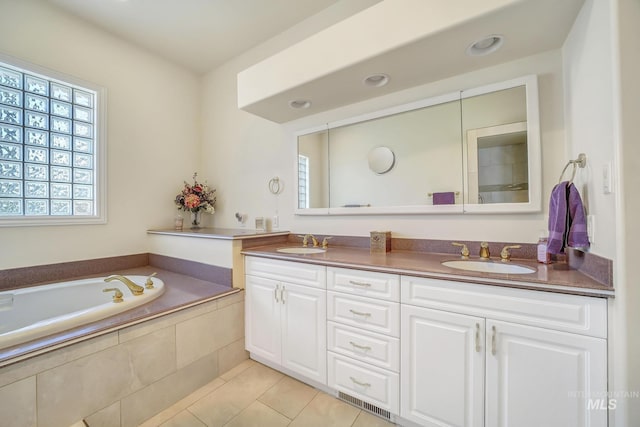 bathroom featuring tile patterned floors, vanity, and tiled bath