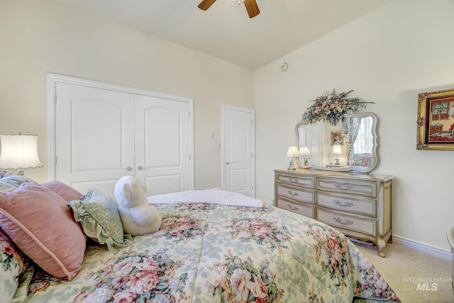 bedroom featuring ceiling fan, a closet, carpet, and vaulted ceiling