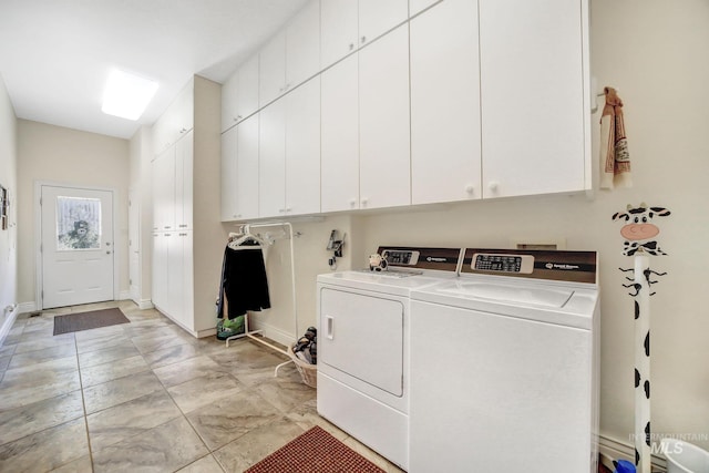 clothes washing area featuring cabinets and washing machine and dryer