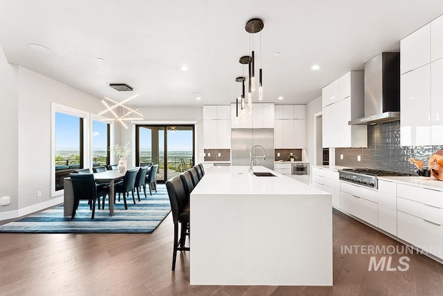 1519 S Galaxy Way, Boise, ID 83712 - kitchen featuring modern cabinets, wall chimney exhaust hood, stainless steel gas cooktop, decorative backsplash, and white cabinetry