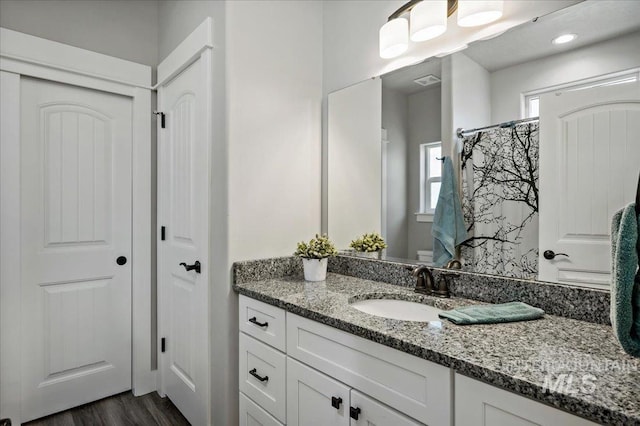 bathroom with a shower with shower curtain, hardwood / wood-style floors, and vanity