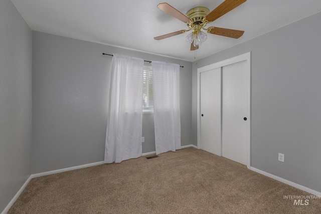 unfurnished bedroom with a closet, carpet flooring, and baseboards