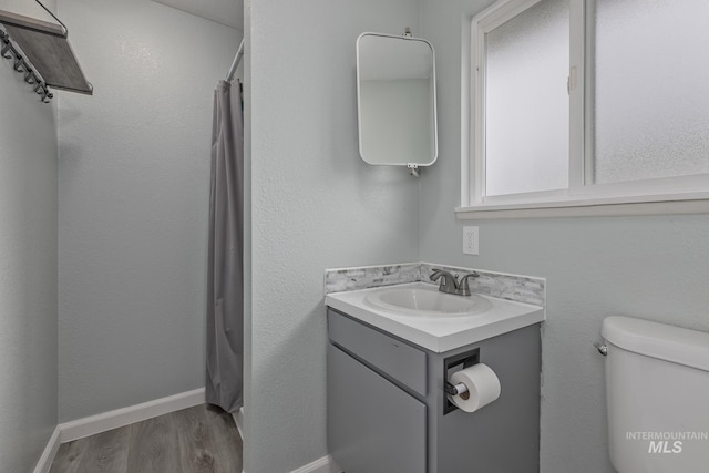 full bath featuring vanity, baseboards, toilet, and wood finished floors