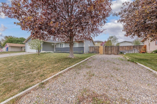 view of front of house with fence, driveway, a front yard, and a garage