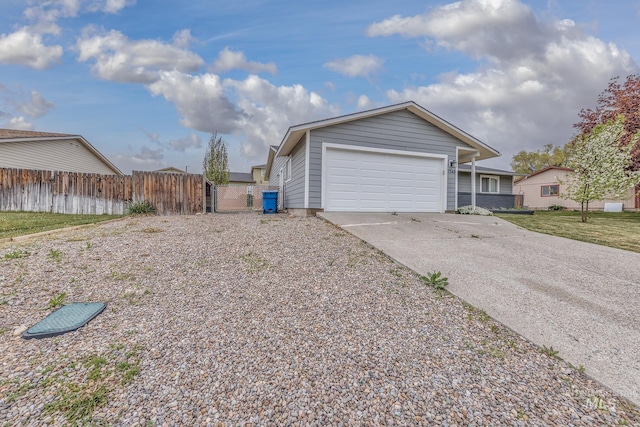 view of property exterior featuring fence, concrete driveway, and a garage