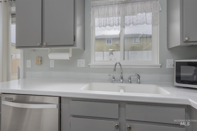 kitchen featuring a sink, appliances with stainless steel finishes, and gray cabinets