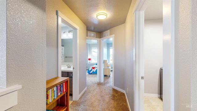 133 S Baraya Way, Meridian, ID 83642 - hallway featuring a textured wall, light colored carpet, a sink, and baseboards