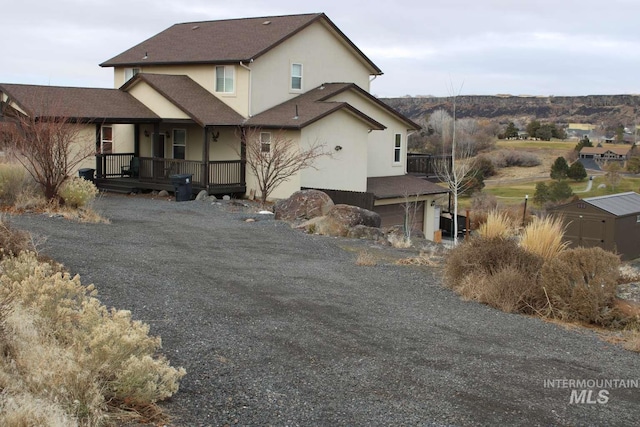 back of house featuring stucco siding and a porch