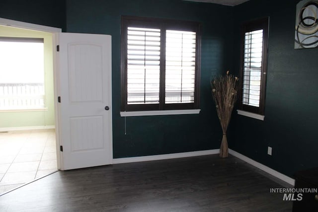 unfurnished room featuring baseboards and wood finished floors