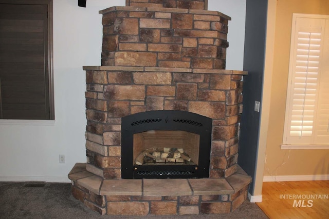 interior details featuring baseboards and a stone fireplace