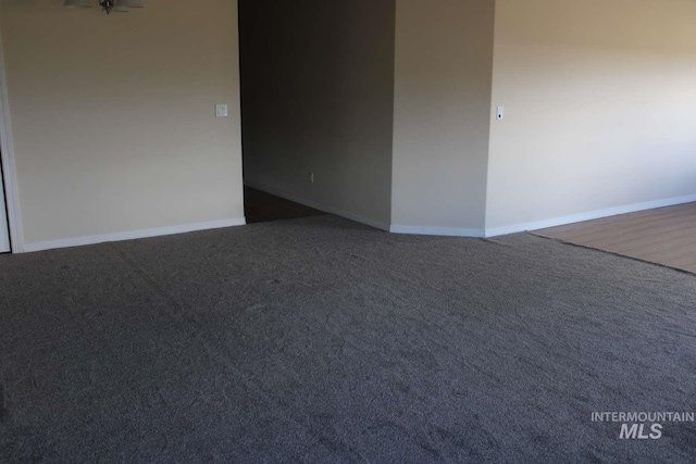 carpeted spare room featuring baseboards