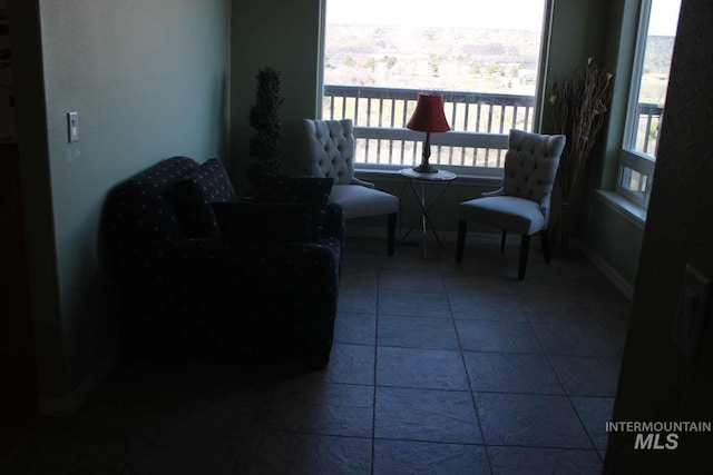 sitting room with baseboards and tile patterned flooring