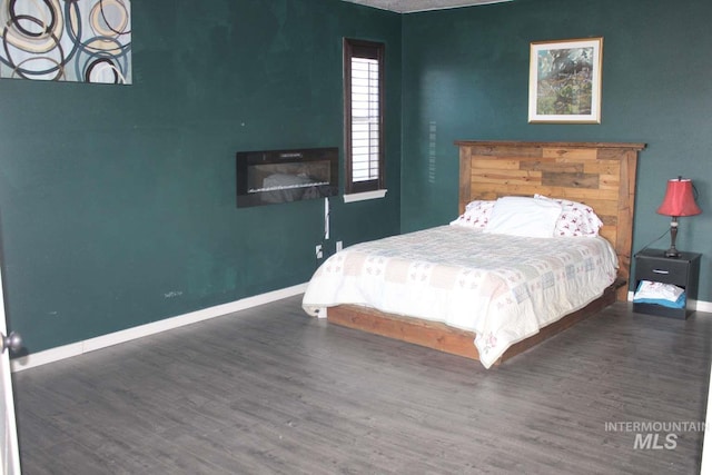 bedroom with baseboards and wood finished floors