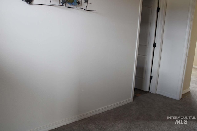 spare room featuring baseboards and carpet flooring