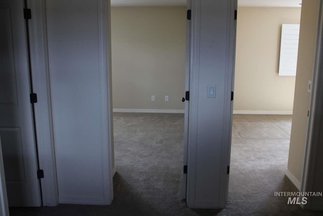 hall featuring baseboards and carpet floors
