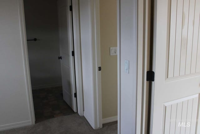corridor with baseboards and carpet flooring