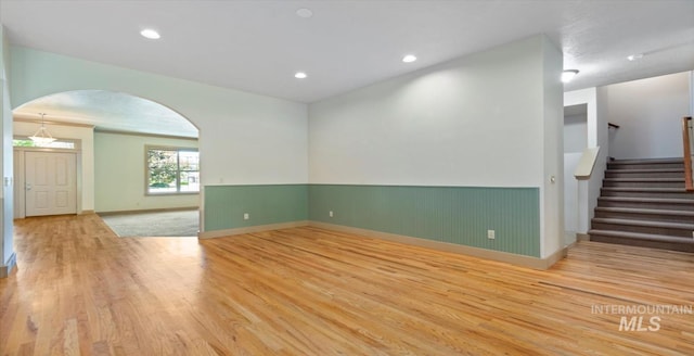 1563 W Colville Ct, Eagle, ID 83616 - unfurnished room with wood finished floors, arched walkways, wainscoting, stairway, and recessed lighting