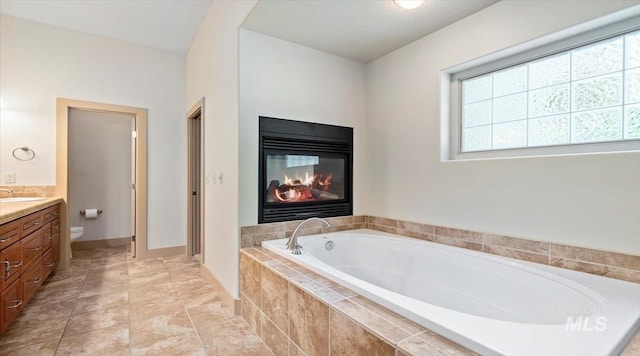 1563 W Colville Ct, Eagle, ID 83616 - bathroom with vanity, a garden tub, plenty of natural light, and a glass covered fireplace