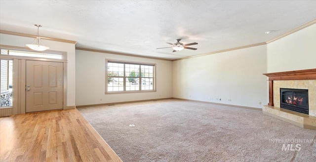 1563 W Colville Ct, Eagle, ID 83616 - unfurnished living room with ornamental molding, a ceiling fan, light colored carpet, and a tiled fireplace