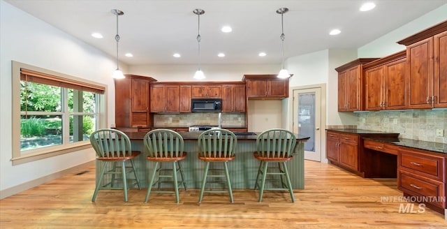 1563 W Colville Ct, Eagle, ID 83616 - kitchen featuring black microwave, dark countertops, decorative backsplash, light wood-style floors, and recessed lighting