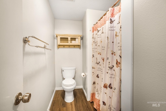 full bathroom featuring baseboards, a shower with curtain, toilet, and wood finished floors
