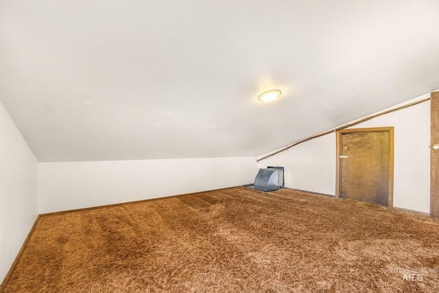additional living space with carpet flooring and vaulted ceiling