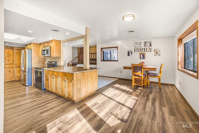kitchen featuring stainless steel appliances, baseboards, recessed lighting, and wood finished floors
