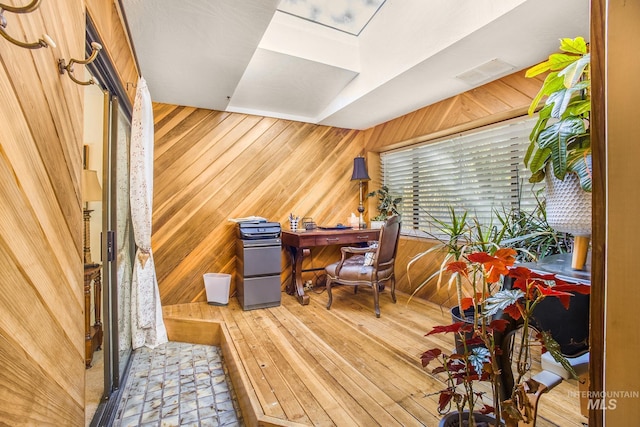 home office with visible vents, wood walls, and hardwood / wood-style flooring