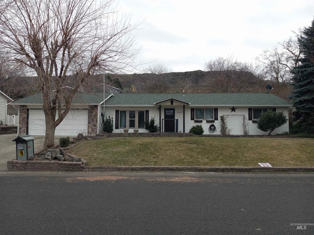 ranch-style home featuring a garage and a front lawn