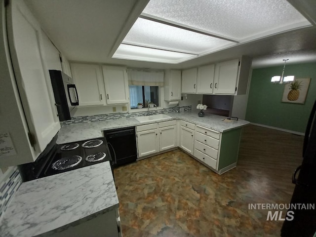 kitchen with sink, black appliances, kitchen peninsula, pendant lighting, and white cabinets