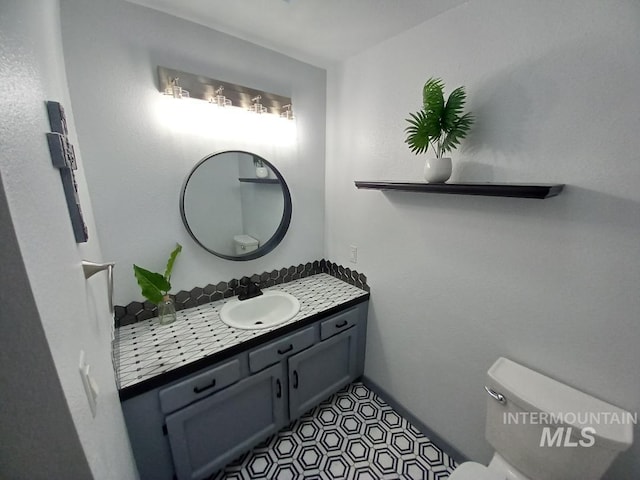 bathroom featuring vanity, tile patterned flooring, and toilet