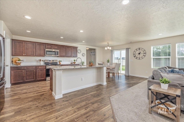 19118 Ralston Way, Caldwell, ID 83605 - kitchen featuring stainless steel appliances, a textured ceiling, dark wood-style flooring, recessed lighting, and open floor plan