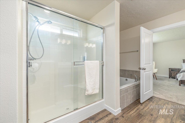 19118 Ralston Way, Caldwell, ID 83605 - ensuite bathroom featuring wood finished floors, a garden tub, a shower stall, and a textured ceiling