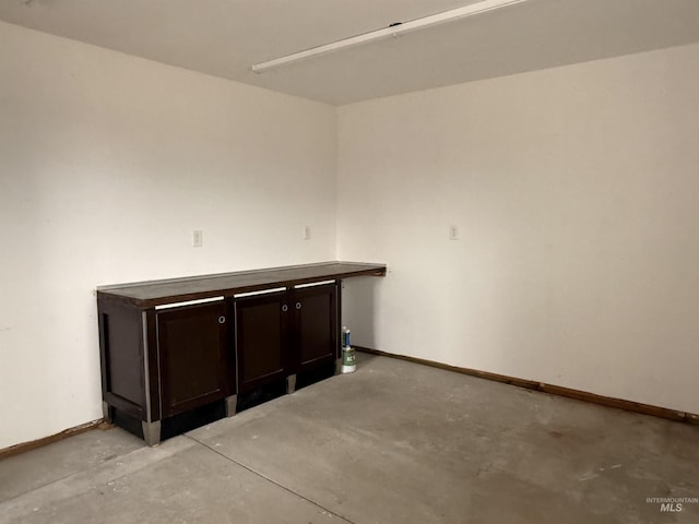 spare room with baseboards and concrete floors