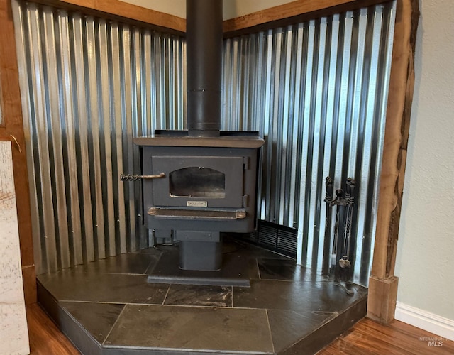 details featuring a wood stove and wood finished floors