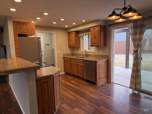 kitchen with a sink, brown cabinetry, visible vents, and stainless steel appliances