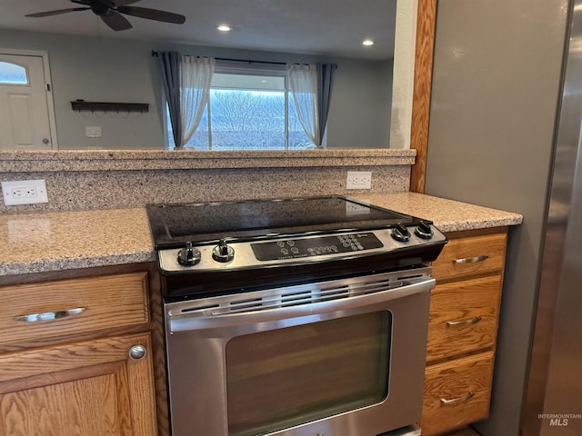 kitchen featuring brown cabinetry, recessed lighting, stainless steel electric range, ceiling fan, and light countertops