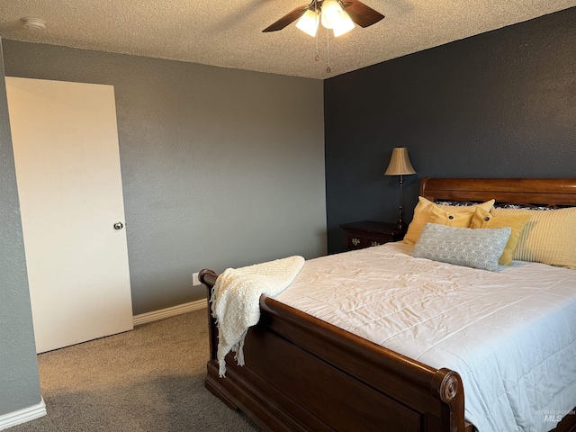 bedroom featuring baseboards, ceiling fan, carpet, a textured wall, and a textured ceiling