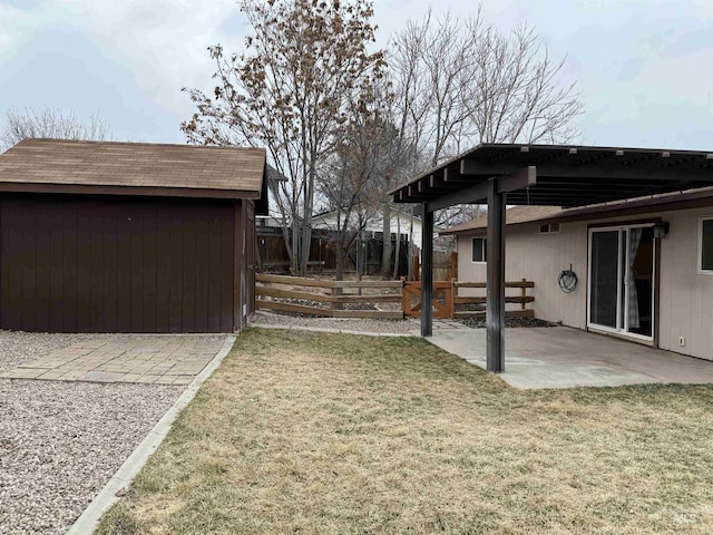 view of yard featuring an outbuilding, a patio area, and fence