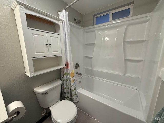 bathroom featuring shower / bathtub combination with curtain, toilet, and a textured wall