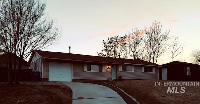 ranch-style house with an attached garage and driveway