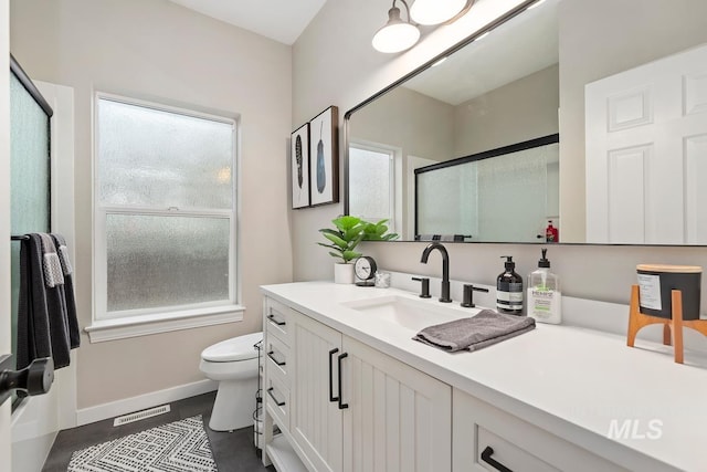 bathroom with vanity, an enclosed shower, and toilet