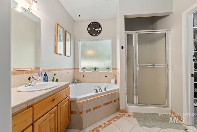 bathroom featuring tile patterned flooring, vanity, and shower with separate bathtub