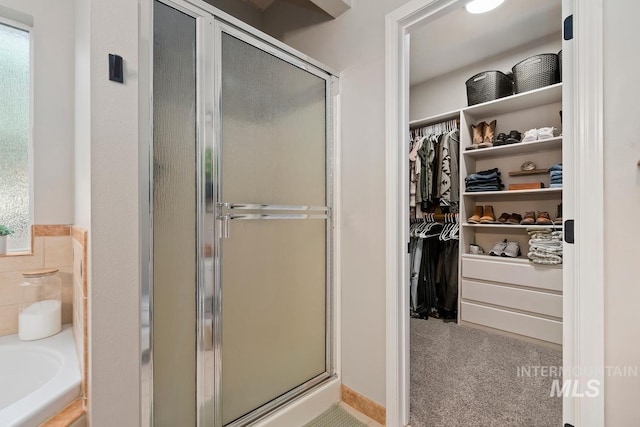 bathroom with shower with separate bathtub and a wealth of natural light