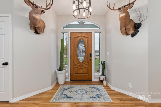 foyer entrance featuring hardwood / wood-style flooring and a chandelier