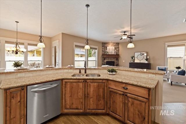 kitchen featuring a fireplace, open floor plan, dishwasher, and a sink