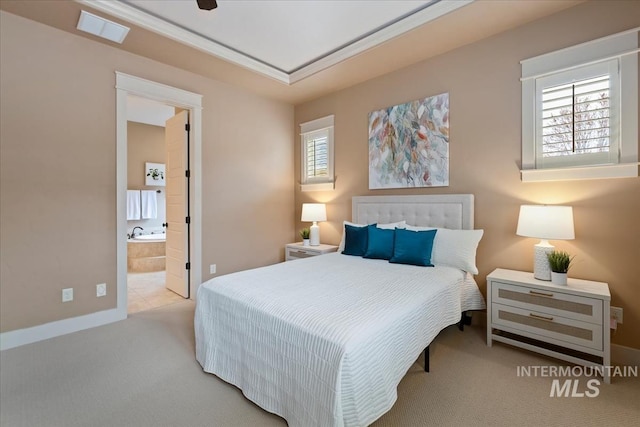 carpeted bedroom with visible vents, baseboards, and connected bathroom