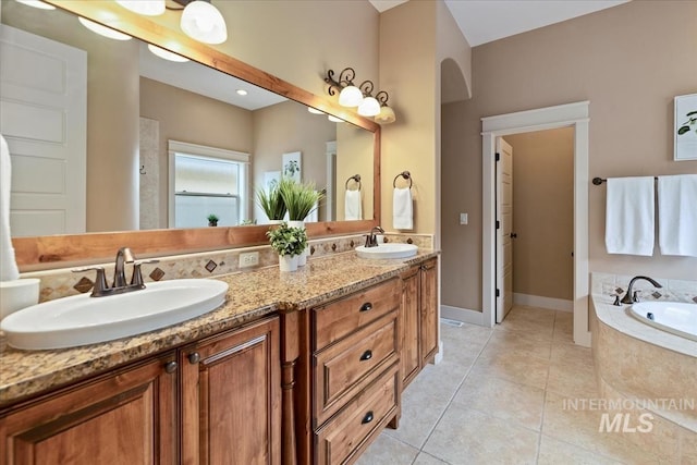 bathroom with tile patterned floors, a bath, and a sink