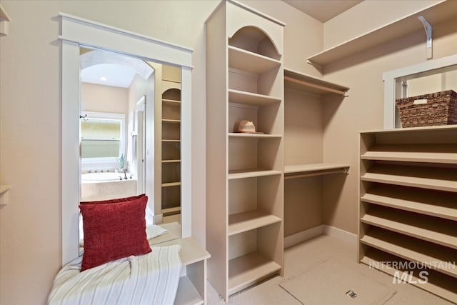 walk in closet with arched walkways