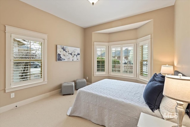 bedroom with carpet flooring, baseboards, and multiple windows